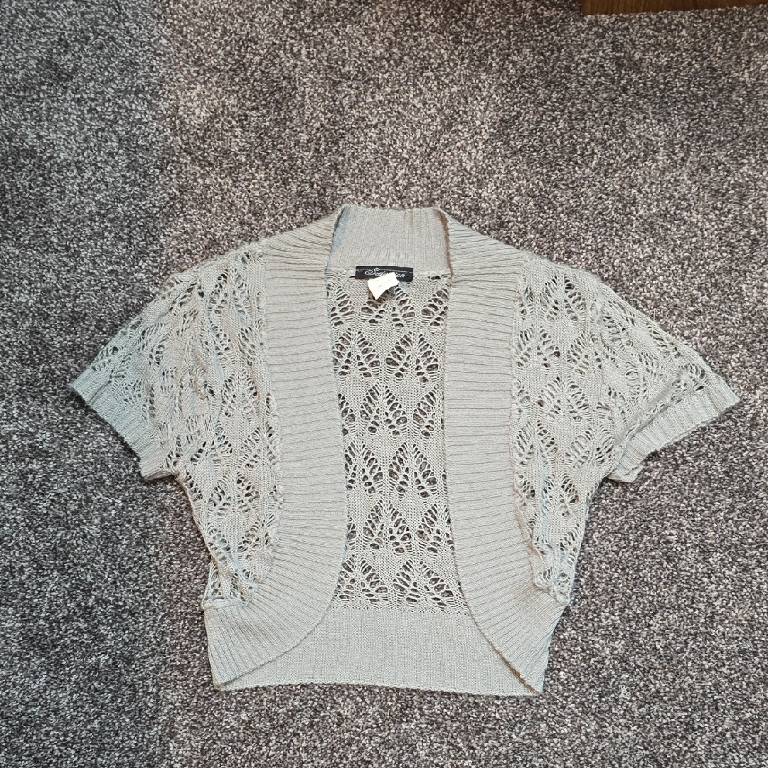 A knitted shrug or bolero cardigan photographed for a US resale listing in September 2026